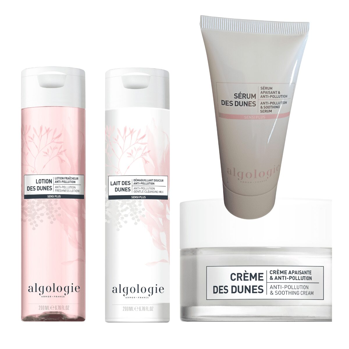 The Soothing Super Size Serum Set from Algologie's Des Dunes line features two tall bottles, a tube, and a jar, all in white and light pink packaging with botanical accents.